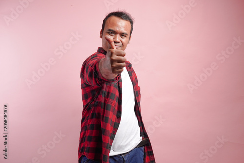 Quadro su tela A man with a thumbs up gesture is smiling and wearing a red plaid shirt
