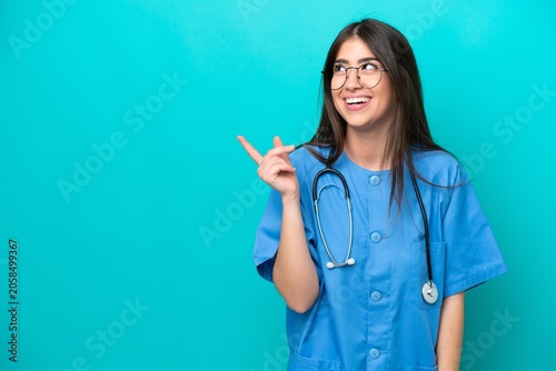 Billede på lærred Young nurse caucasian woman isolated on blue background intending to realizes th