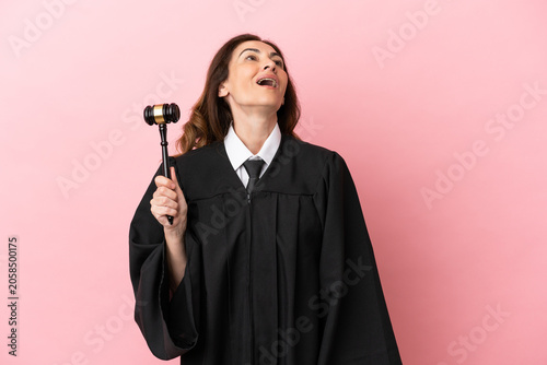 Fotografie Middle aged judge woman isolated on pink background laughing