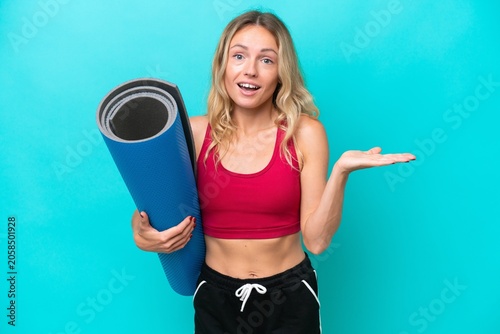 Bild auf Leinwand Young sport Russian woman going to yoga classes while holding a mat isolated on