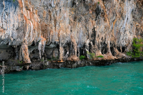 Tropical limestone cliff texture above turquoise sea in Thailand