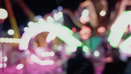 Blurred Carnival Lights With Colorful Bokeh At Amusement Park At Night