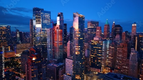 Stunning glossy high-rises reflecting the city lights. Drone flight among the gorgeous buildings of New York City at dusk time.