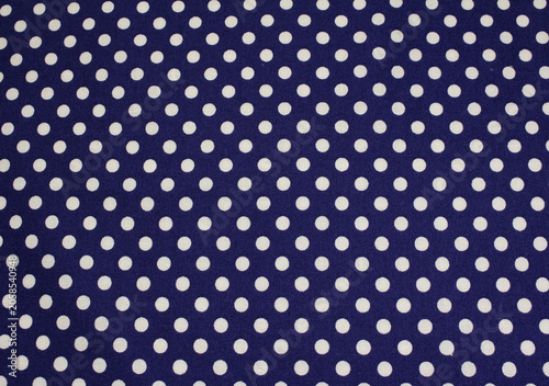 Close up of classic polka dot pattern cotton cloth. Texture of blue fabric with white polka dots background. 