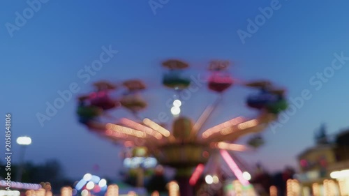 Blurred Carnival Lights With Colorful Bokeh At Amusement Park At Night