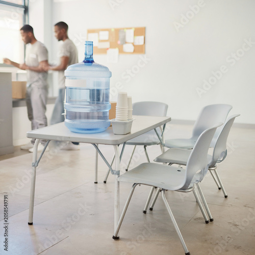 Water cooler and cups in modern office break room