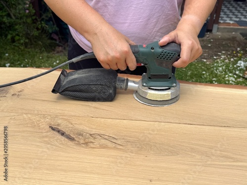 Carpenter Sanding Wooden Table in Workshop