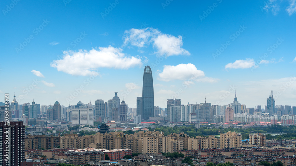 Obraz premium City Skyline With Tall Modern Skyscraper Under Clear Blue Sky