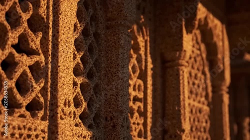 Intricate Carved Stone Lattice Patterns In Historical Temple Architecture With Warm Sunset Lighting