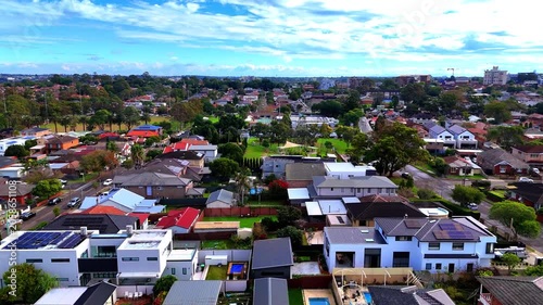 Drone panoramic aerial view of Sydney NSW Australia city Skyline and looking down on all suburban houses and streets of western Sydney of Burwood and Enfield