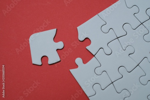 Obraz na plátně Missing puzzle piece on a red background