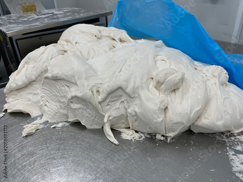 Fresh dough after industrial mixing and kneading process, prepared for steamed bun production. Dough development stage supporting product consistency and large-scale bakery manufacturing.