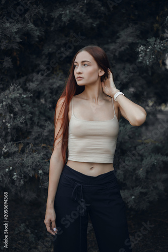 Model poses outdoors in a casual outfit during a sunny day in a park