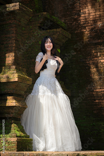 Portrait Fashion Asian Woman in White Gown at Ancient Brick Temple Architecture in Chiang Mai Thailand