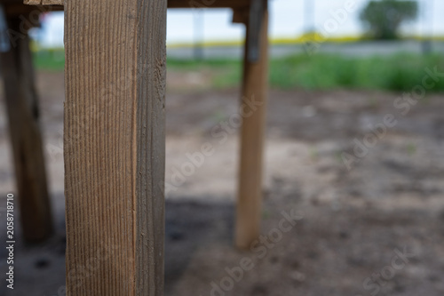 Rough wooden workbench made from reclaimed lumber outdoors, close-up of rustic DIY construction table on a building site.