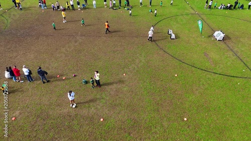 Children playing soccer with parents watching them in a western Sydney Park on a Sunday winter morning in Enfield Sydney NSW Australia