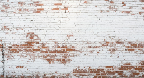 White painted brick wall with distressed red brick texture. Weathered white painted brick wall background.