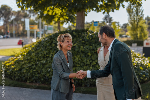 Business people shaking hands making agreement outdoors
