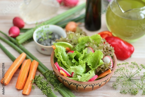 Fresh lettuce of different kinds served in the bowl. Healthy lettuce salad, radish and carrot.