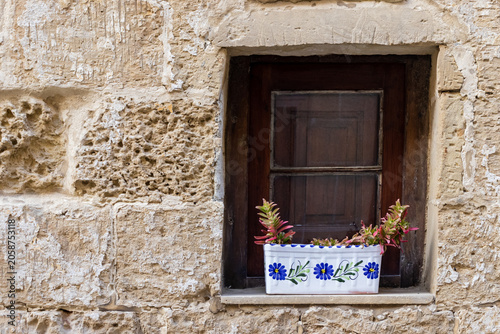 Billede på lærred Sunlit Stone Building, Wooden Window With Colorful Flower Boxes On Mediterranean