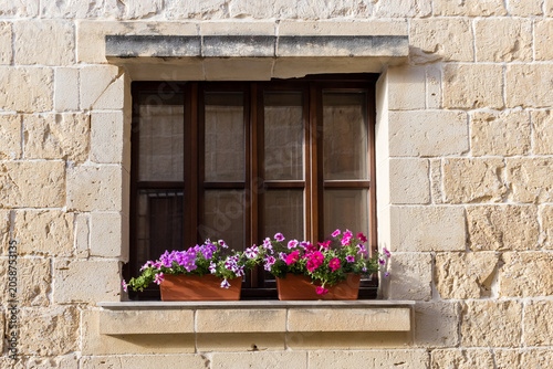 Billede på lærred Sunlit Stone Building, Wooden Window With Colorful Flower Boxes On Mediterranean