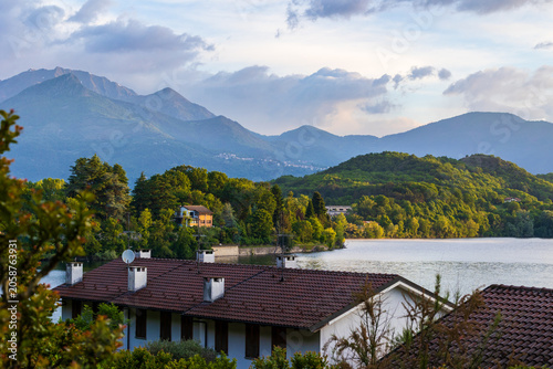 Villas on the shores of the Lago Grande di Avigliana surrounded by Alpine mountains at sunrise, Avigliana Nature Park, Susa Valley