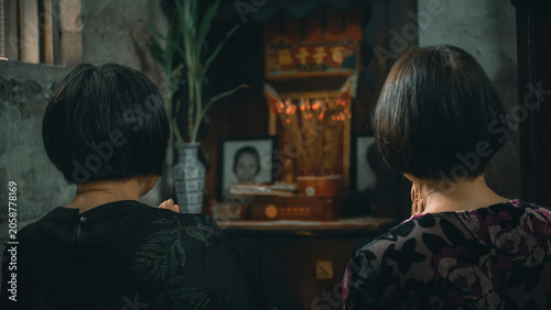 two women are praying for their ancestors