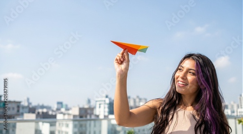 Young woman holding colorful paper airplane
