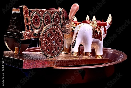 Obraz na plátně Cinematic close up of traditional Indian miniature bullock cart isolated on black background