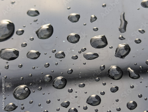 Tableau sur toile This image depicts numerous water droplets on a reflective surface, resembling a hydrophobic coating or rain on a polished metallic finish
