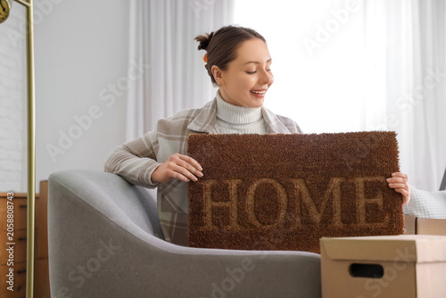 Young woman with door mat s...
