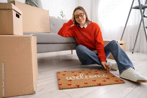 Young woman with doormat si...