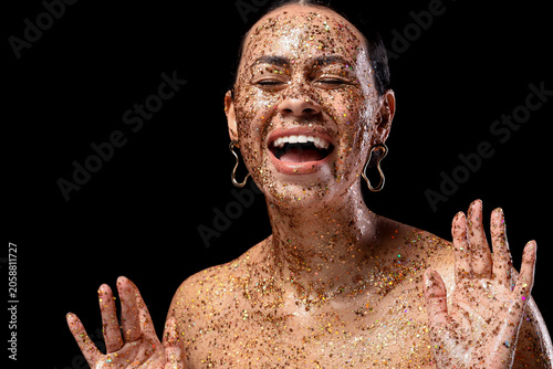 Joyful woman covered in gol...