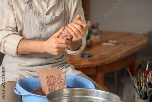 Potter shaping clay with ha...