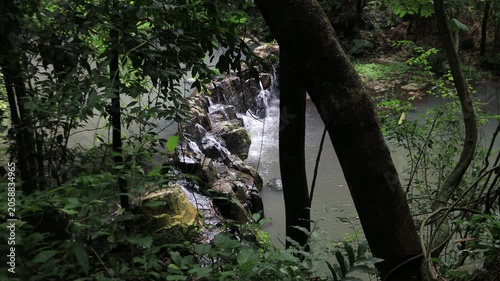The video background features a natural landscape of a waterfall in a lush forest. Sam Lan Waterfall in Saraburi National Park boasts beautiful flowing water surrounded by diverse flora.