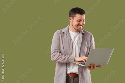 Man with laptop on color  b...