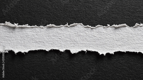 Torn White Paper Strip with Rough Ripped Edges on Black Background
