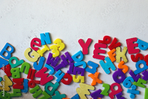 Quadro su tela A jumbled pile of vibrant multi colored plastic toy alphabet magnets scattered r