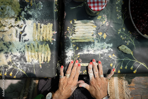 Elderly lady rolling pasta