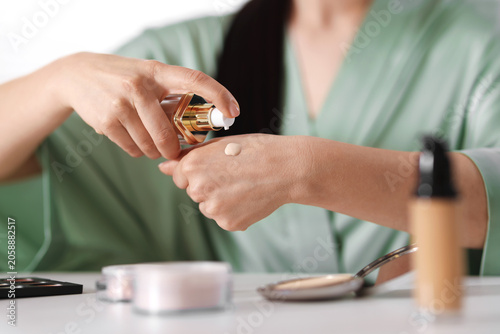 Cuadro en lienzo Woman applying foundation onto her hand at table indoors, closeup