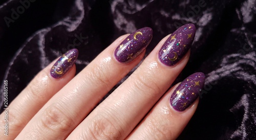 celestial purple manicure with gold moon and star glitter almond nails on dark velvet
