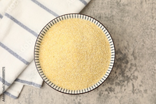 Obraz na plátně Raw semolina in bowl on grey table, top view