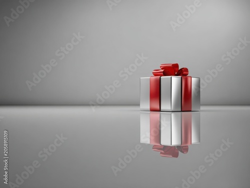 Silver gift box with red ribbon on reflective gray background  