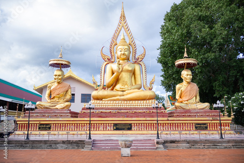 Foto Large golden Buddha statue with revered monk sculptures in a Thai temple