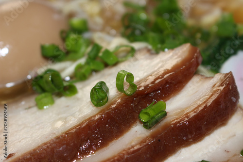 Fresh meat slices with green onion and egg. ramen ingredients preparation closeup. Meat with selective focus. Details of meat with green onion and egg to prepare ramen.