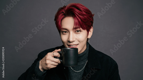 Young Asian Man with Red Hair Holding a Black Mug