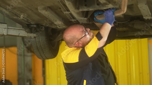 Caucasian male mechanic with glasses and a beard works alongside a female technician, reviewing a digital tablet and giving a thumbs-up. This high-energy commercial imagery represents gender diversity