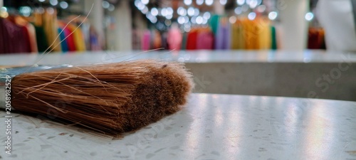Professional paintbrush with natural brown bristles on white stone surface, close up of painting tool in artist studio, creative workshop background