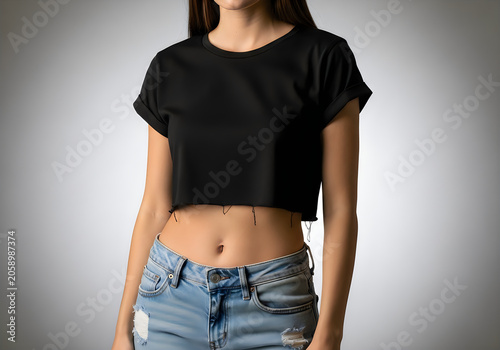 Young woman wearing a black crop top and distressed blue jeans