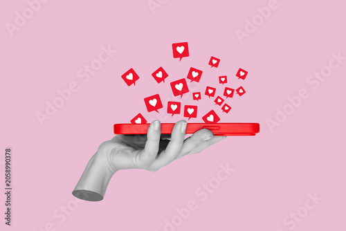 Gray statue hand holding red smartphone with floating social media like icons isolated on pink background. Contemporary art collage about online attention and digital engagement